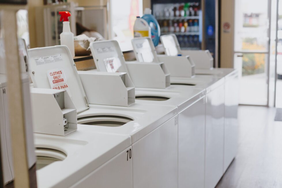 A row of white washing machines in a room.